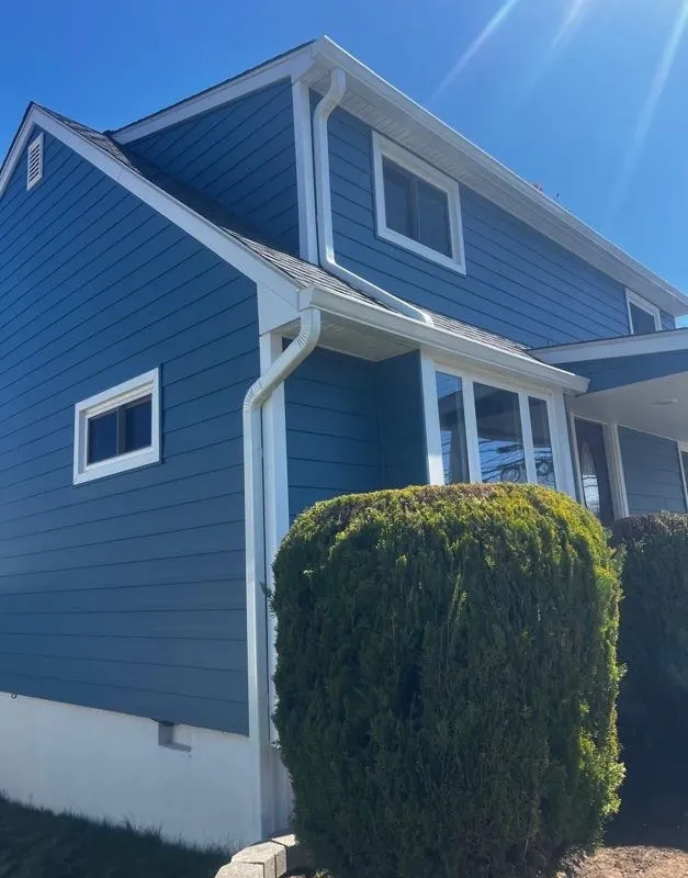 Home with newly installed blue horizontal siding, corner detail