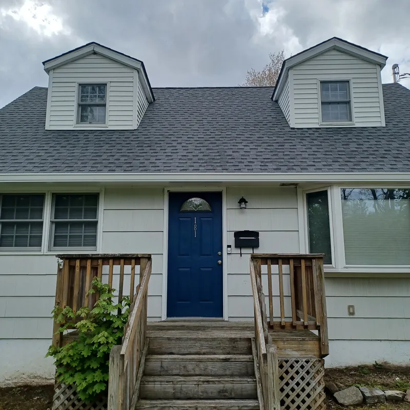 Completed new architectural shingle roof with dormer windows on a cape-style home